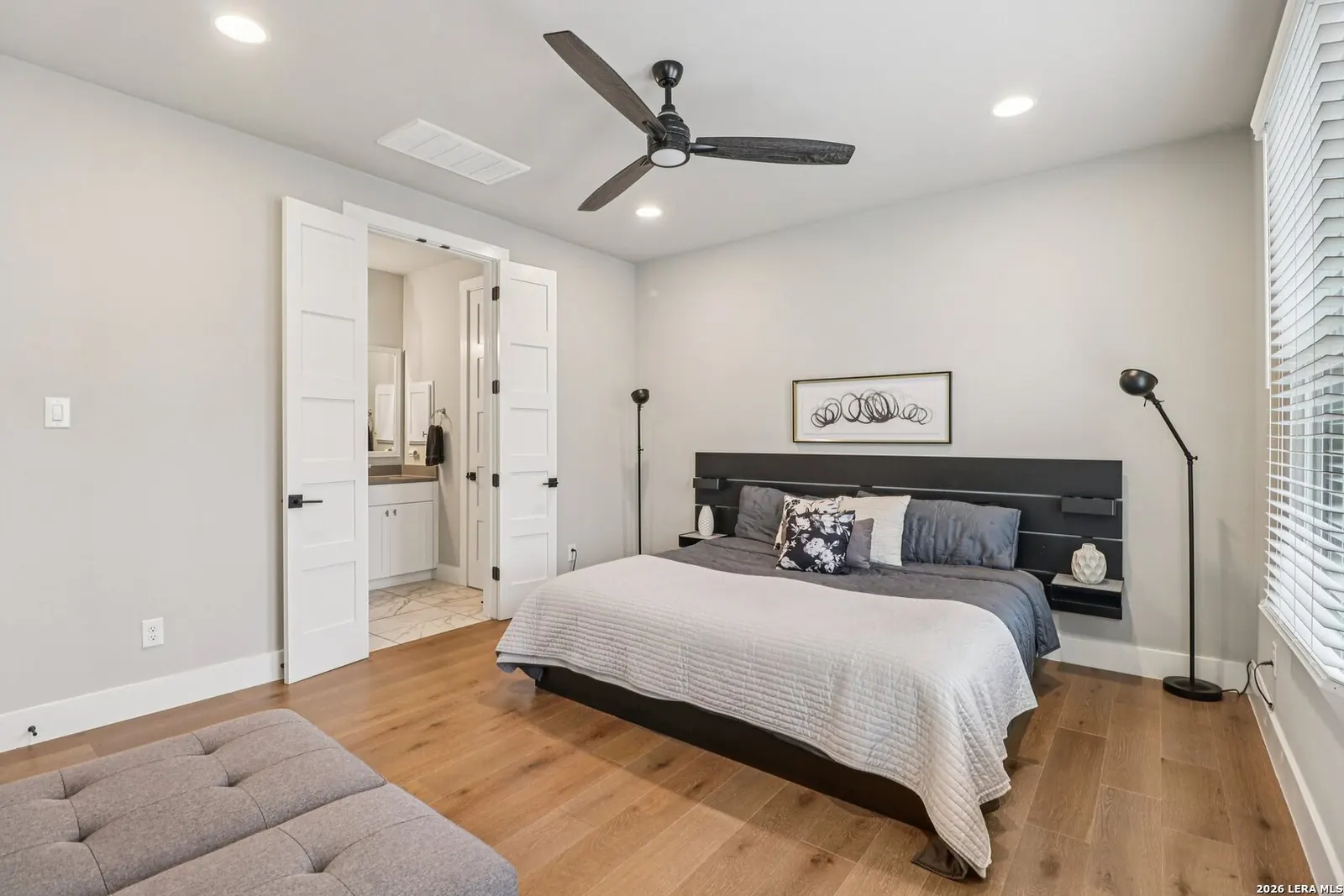Primary bedroom staged with gray bedding and clean side tables