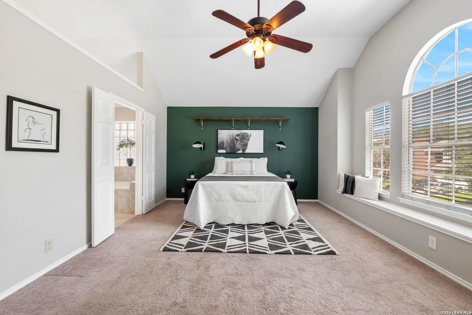 Bedroom staged with green accent wall and arched window
