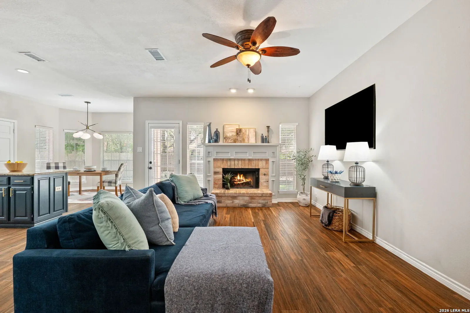 Staged living room with blue seating and fireplace focal point